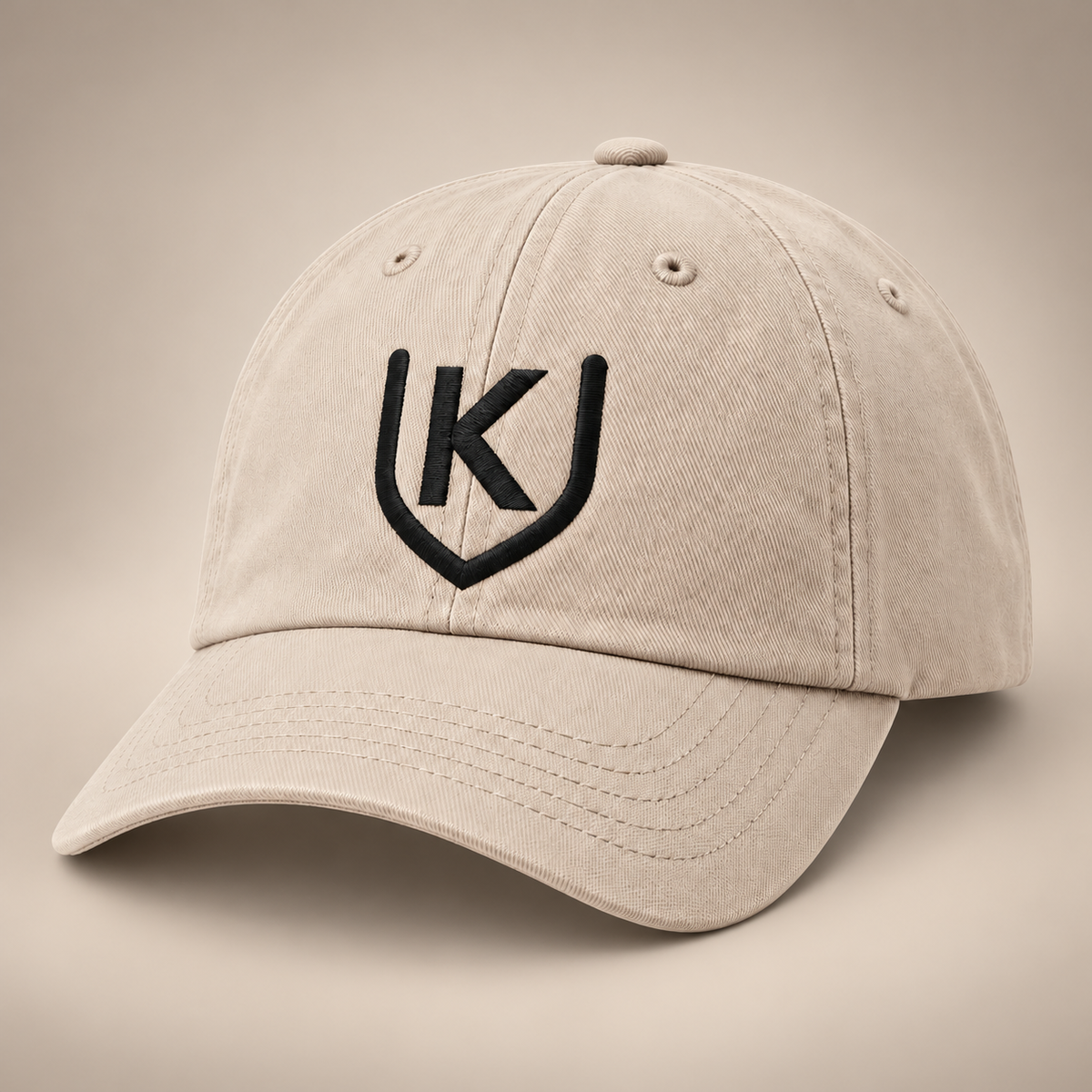 Stone six-panel cap with a curved visor and black K-shield embroidery on the front crown.