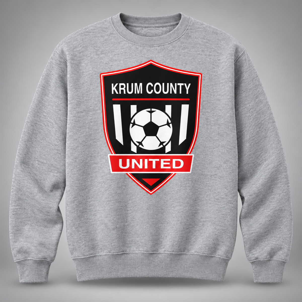 Heather-grey men's crewneck sweatshirt with a large red, black, and white Krum County United crest.