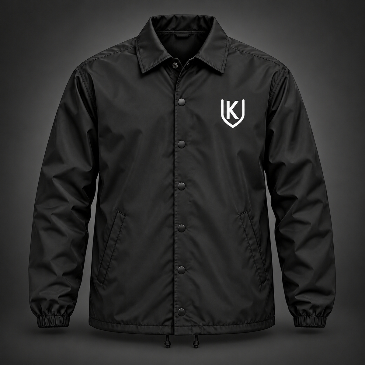 Black Krum County United snap-front coach jacket with a small white shield mark on the left chest.